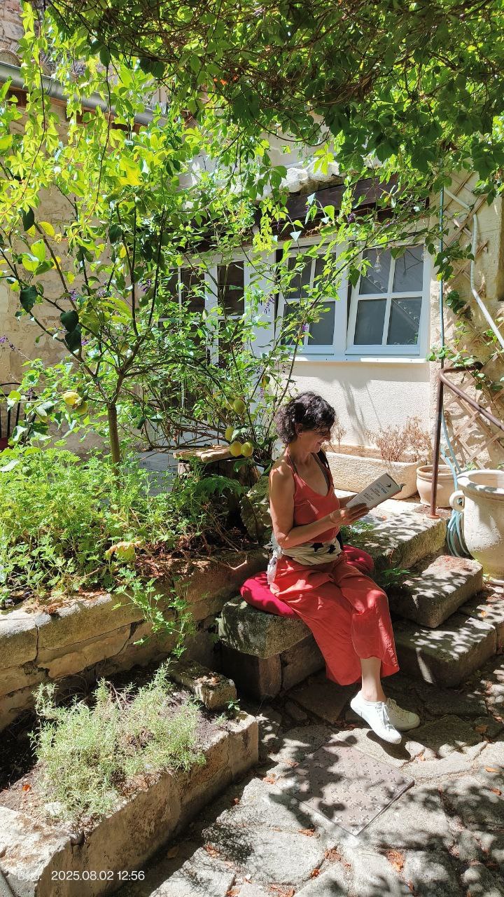 Célie, lisant un livre dans un jardin ensoleillé