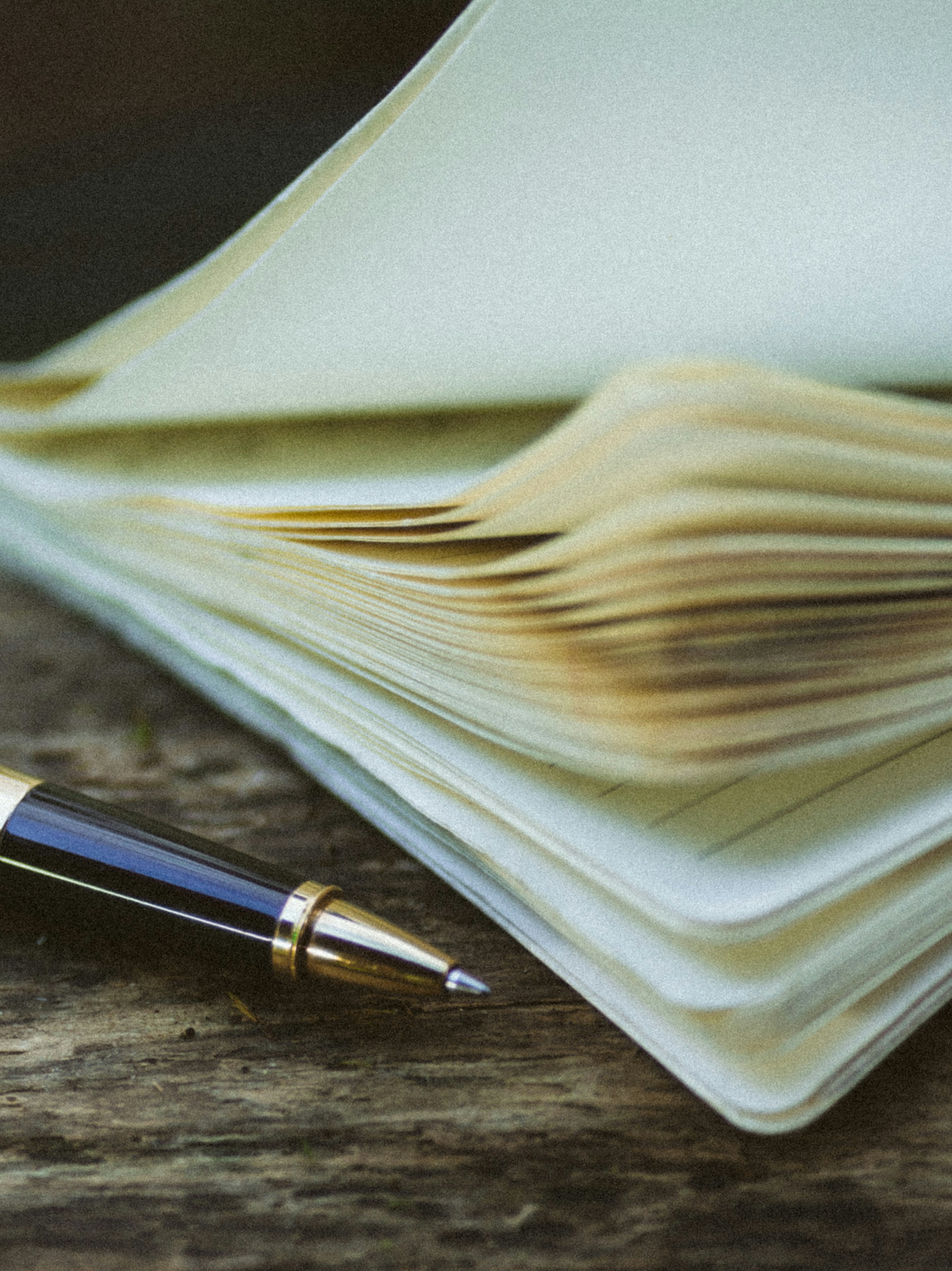 Un carnet ouvert et un stylo posés sur une table en bois